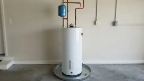 New tank water heater with an expansion tank and copper piping on a basement floor